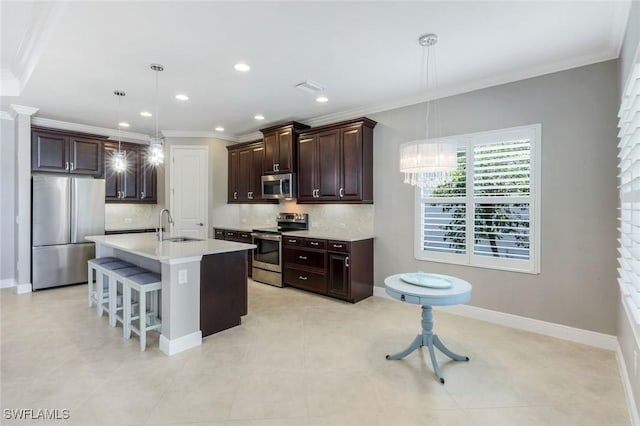 kitchen featuring stainless steel appliances, a sink, tasteful backsplash, ornamental molding, and a kitchen bar
