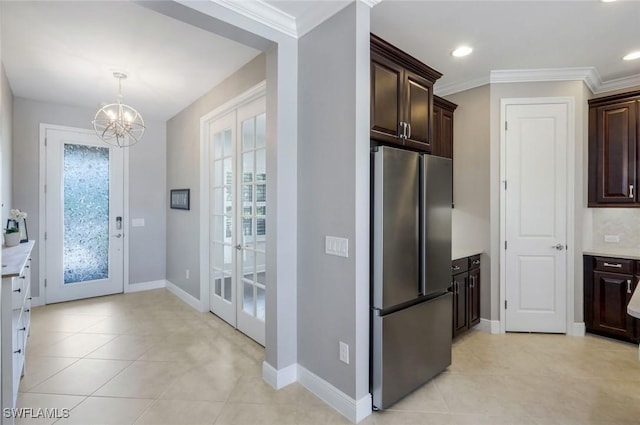 kitchen featuring freestanding refrigerator, french doors, dark brown cabinets, a chandelier, and light countertops