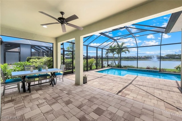 outdoor pool with a water view, a patio area, glass enclosure, and a ceiling fan