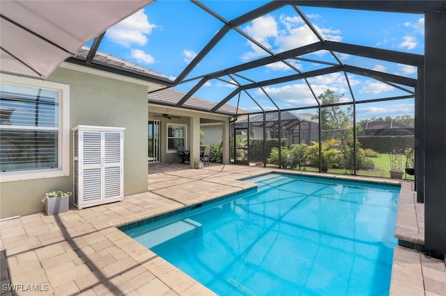 swimming pool featuring a patio area, a ceiling fan, and glass enclosure