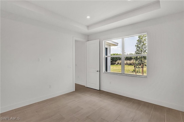 spare room with baseboards, a healthy amount of sunlight, and wood tiled floor