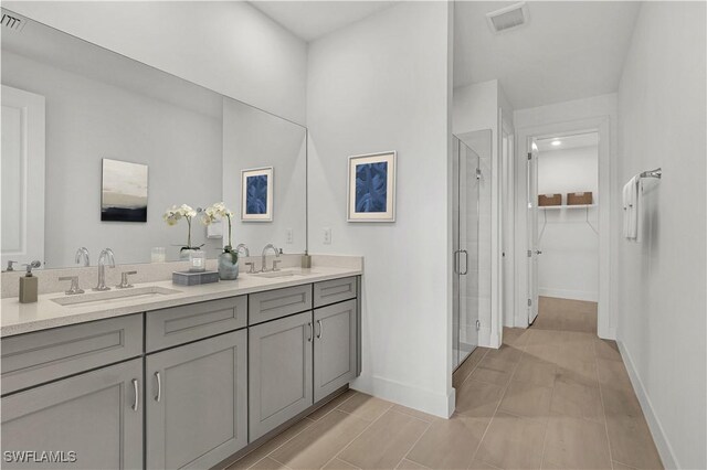 44332 Panther Dr, Punta Gorda, FL 33982 - bathroom with a stall shower, double vanity, a spacious closet, and baseboards