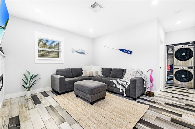 1330 Rock Rd, Naples, FL 34120 - living area featuring visible vents, a glass covered fireplace, wood finished floors, baseboards, and stacked washer / drying machine