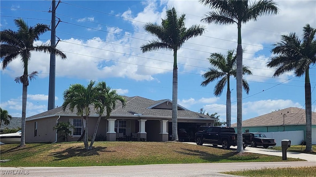 view of front of property featuring concrete driveway, an attached garage, and a front lawn