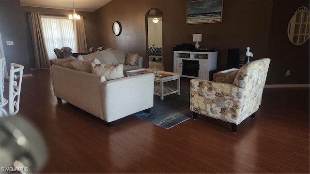 living room featuring dark wood-style floors, baseboards, and a chandelier