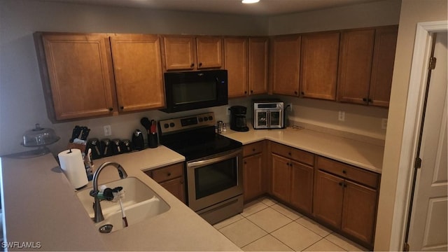 kitchen featuring black microwave, stainless steel range with electric stovetop, a sink, light countertops, and recessed lighting