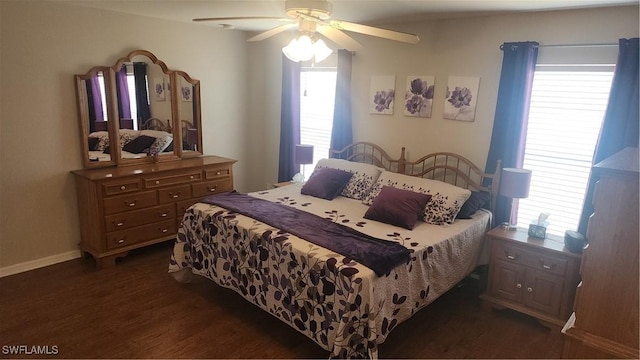 bedroom with multiple windows, dark wood-style floors, ceiling fan, and baseboards