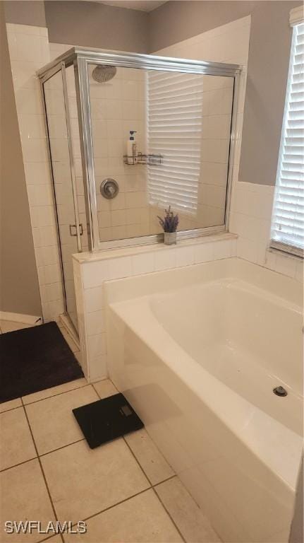 full bathroom featuring tile patterned floors, a garden tub, and a shower stall