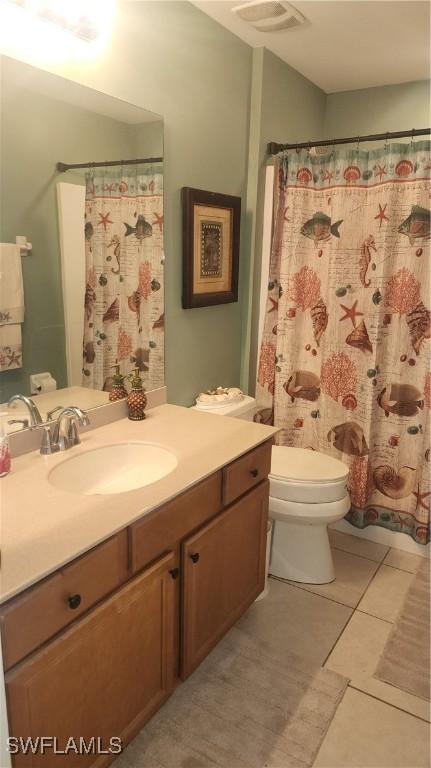 full bathroom with toilet, vanity, tile patterned floors, and curtained shower