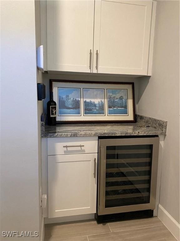 17337 Terracina Dr, Fort Myers, FL 33913 - bar with baseboards, light wood-style flooring, and beverage cooler