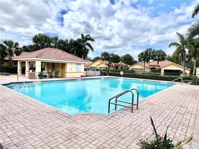 community pool featuring fence and a patio area