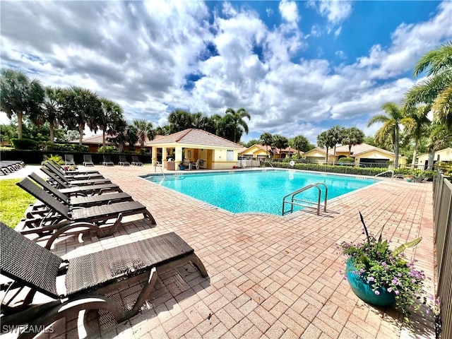community pool featuring fence and a patio