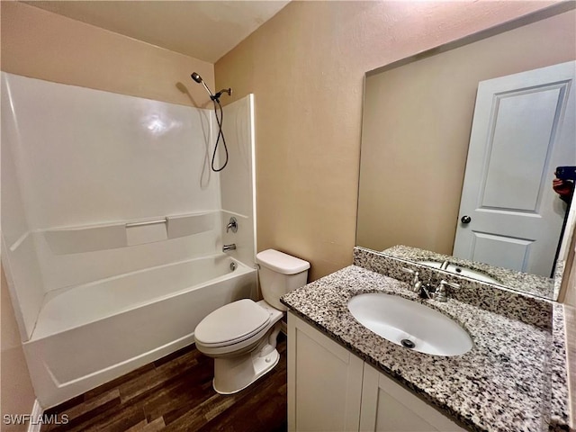 bathroom featuring wood finished floors, toilet, tub / shower combination, and vanity