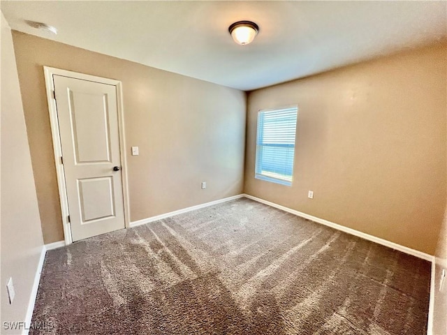 carpeted empty room with baseboards