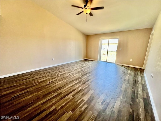 empty room featuring dark wood-type flooring, ceiling fan, baseboards, and vaulted ceiling