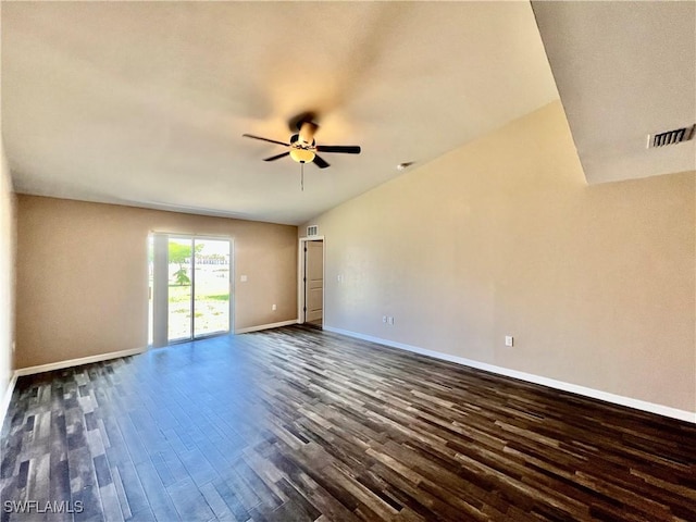 empty room featuring dark wood-type flooring, a ceiling fan, and baseboards