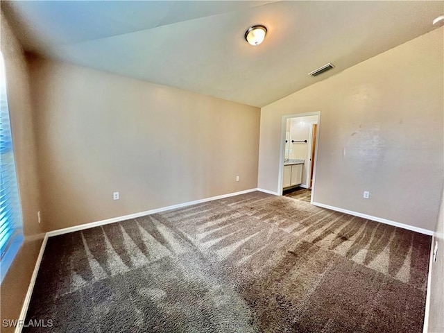 spare room with lofted ceiling, carpet flooring, and baseboards