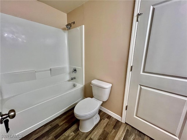 bathroom featuring wood finished floors, toilet, shower / tub combination, and baseboards