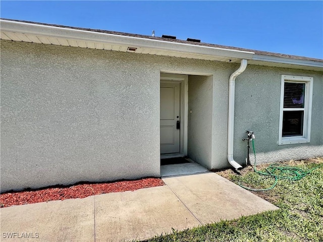 entrance to property featuring stucco siding