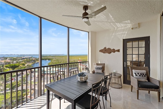 5793 Cape Harbour Dr Unit 1111, Cape Coral, FL 33914 - sunroom featuring a textured ceiling, a healthy amount of sunlight, a water view, a wall of windows, and a textured wall
