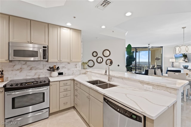 5793 Cape Harbour Dr Unit 1111, Cape Coral, FL 33914 - kitchen with a sink, a peninsula, visible vents, backsplash, and appliances with stainless steel finishes