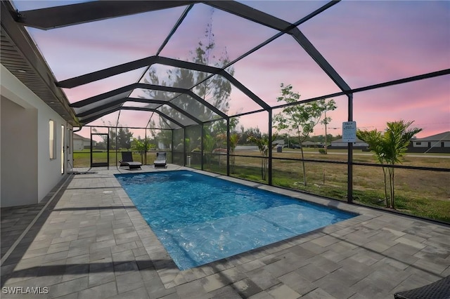 outdoor pool with a patio area and glass enclosure