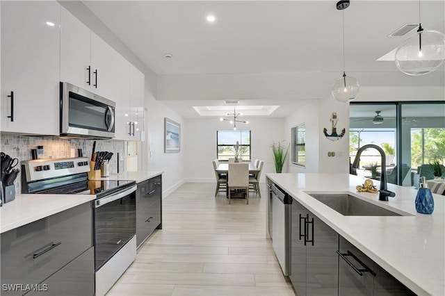 kitchen featuring appliances with stainless steel finishes, a sink, modern cabinets, light countertops, and recessed lighting