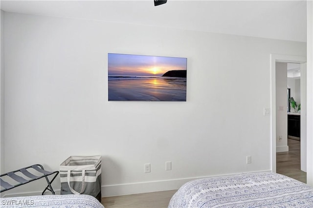 bedroom with baseboards and wood finished floors