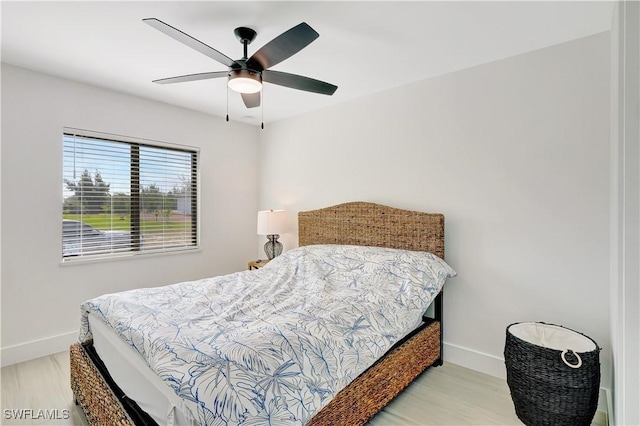 bedroom with baseboards, wood finished floors, and a ceiling fan
