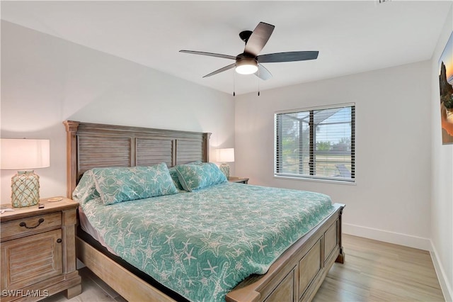 bedroom featuring baseboards, light wood-style floors, and ceiling fan