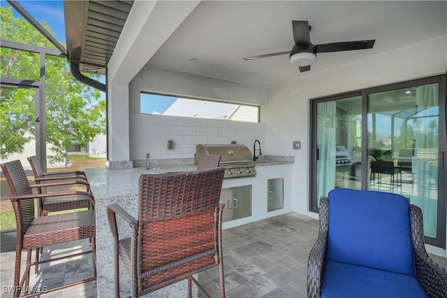 view of patio featuring area for grilling, exterior kitchen, and ceiling fan