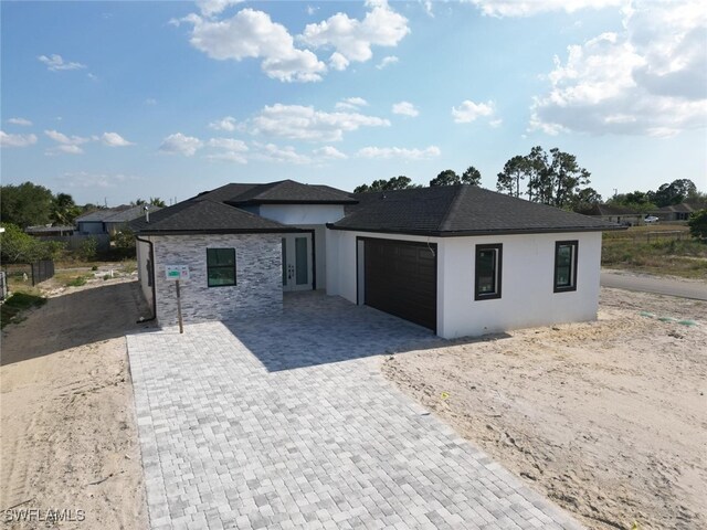 2619 15th St SW, Lehigh Acres, FL 33976 - prairie-style house featuring stucco siding, decorative driveway, and a garage