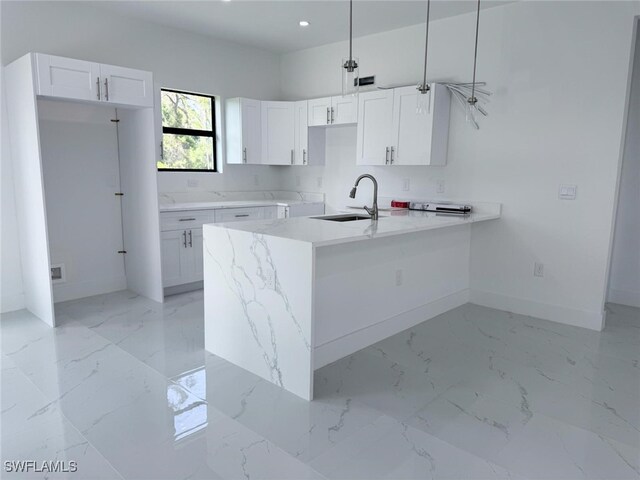2619 15th St SW, Lehigh Acres, FL 33976 - kitchen with a sink, baseboards, white cabinetry, and marble finish floor