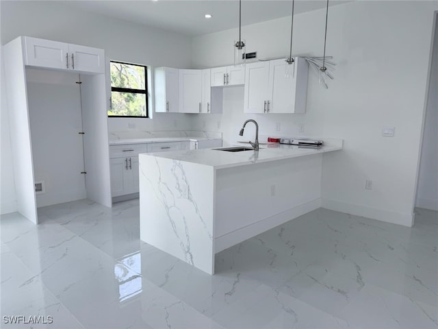 2619 15th St SW, Lehigh Acres, FL 33976 - kitchen with light marble finish flooring, white cabinetry, recessed lighting, a peninsula, and pendant lighting