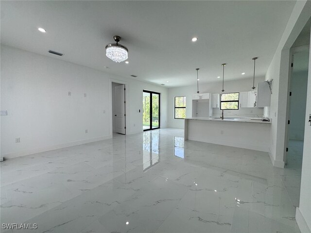 2619 15th St SW, Lehigh Acres, FL 33976 - unfurnished living room with a sink, marble finish floor, recessed lighting, baseboards, and visible vents