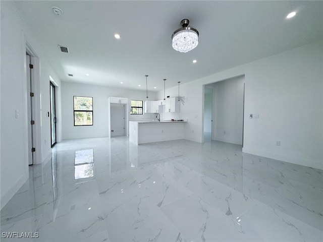 2619 15th St SW, Lehigh Acres, FL 33976 - unfurnished living room with recessed lighting, a chandelier, and light marble finish flooring