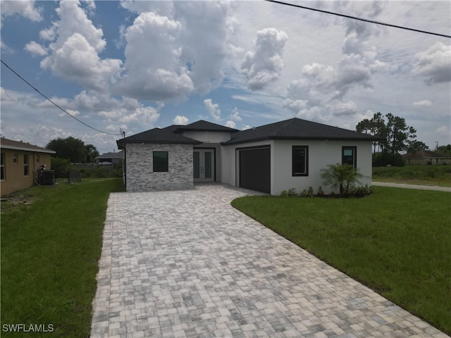 2619 15th St SW, Lehigh Acres, FL 33976 - prairie-style home with decorative driveway, an attached garage, a front yard, and french doors