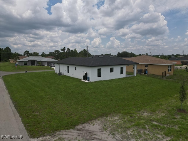 2619 15th St SW, Lehigh Acres, FL 33976 - view of side of home featuring a central AC unit and stucco siding