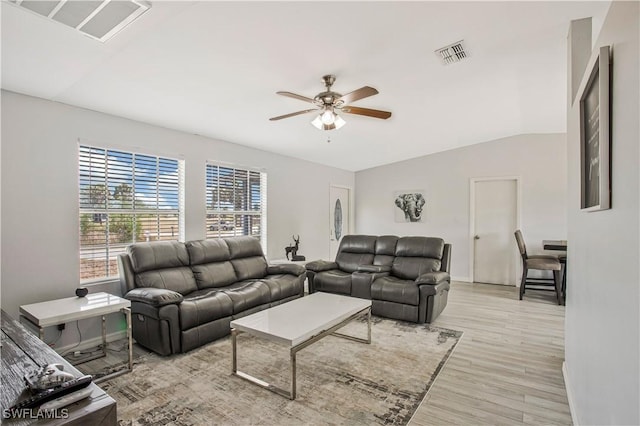 living area featuring a ceiling fan, light wood finished floors, vaulted ceiling, and baseboards