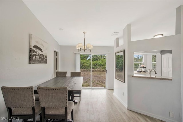dining space with a chandelier, wood finished floors, and baseboards