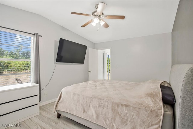 bedroom with vaulted ceiling, light wood-style flooring, baseboards, and ceiling fan