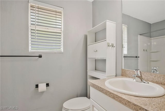 full bath with toilet, vanity, and a shower