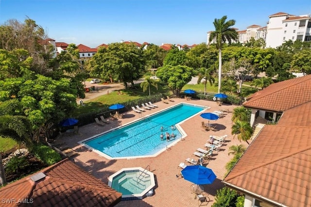 community pool with a patio and a hot tub