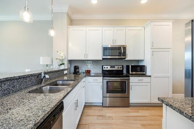 15102 Palmer Lake Cir Unit 201, Naples, FL 34109 - kitchen featuring appliances with stainless steel finishes, ornamental molding, a sink, white cabinets, and decorative light fixtures