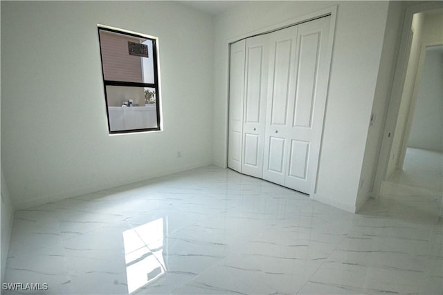 2808 NW 21st Ave, Cape Coral, FL 33993 - unfurnished bedroom with baseboards, marble finish floor, and a closet