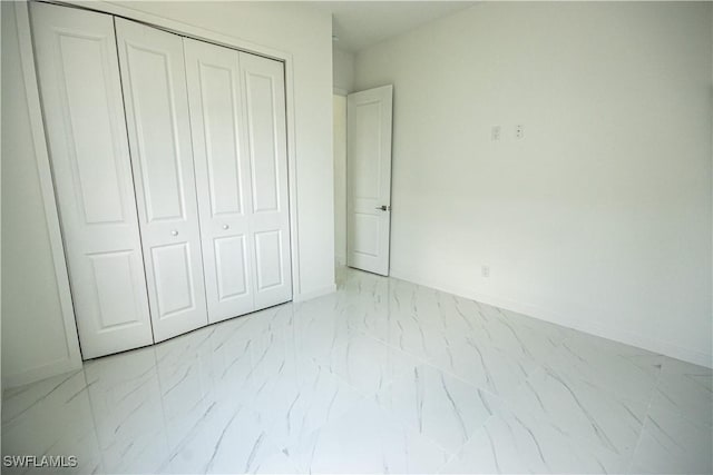 2808 NW 21st Ave, Cape Coral, FL 33993 - unfurnished bedroom featuring baseboards, marble finish floor, and a closet