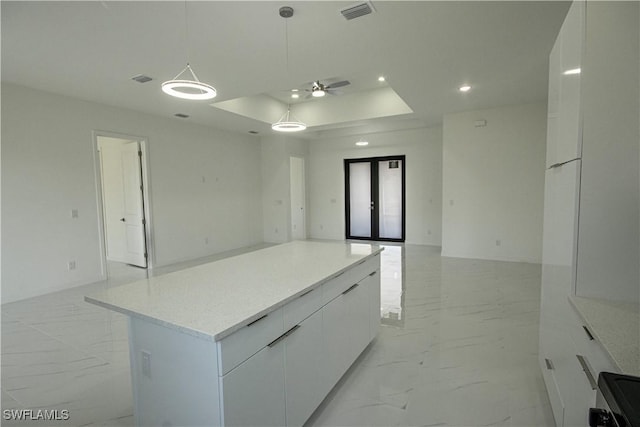 2808 NW 21st Ave, Cape Coral, FL 33993 - kitchen with visible vents, a center island, white cabinets, marble finish floor, and open floor plan