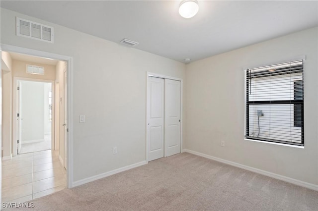 16044 Enclaves Cove Dr, North Fort Myers, FL 33917 - unfurnished bedroom featuring baseboards, visible vents, light carpet, and a closet