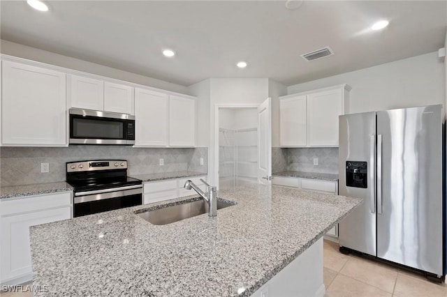16044 Enclaves Cove Dr, North Fort Myers, FL 33917 - kitchen featuring decorative backsplash, light stone countertops, white cabinetry, a sink, and stainless steel appliances