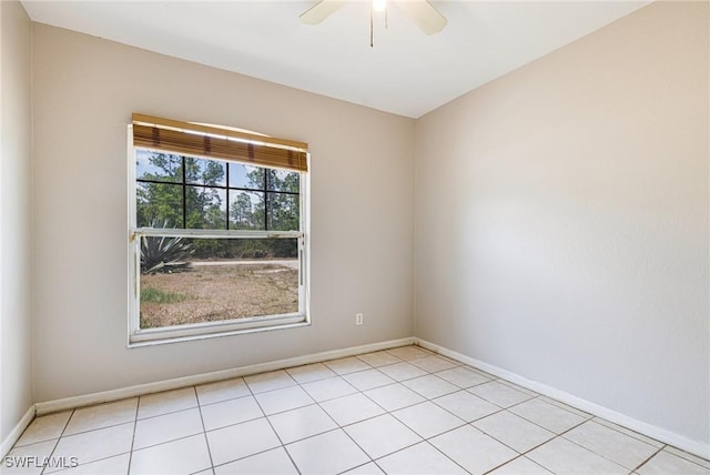 empty room with light tile patterned floors, baseboards, and ceiling fan